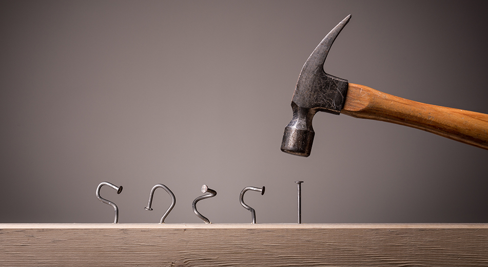 several nails under a hammer that were started incorrectly