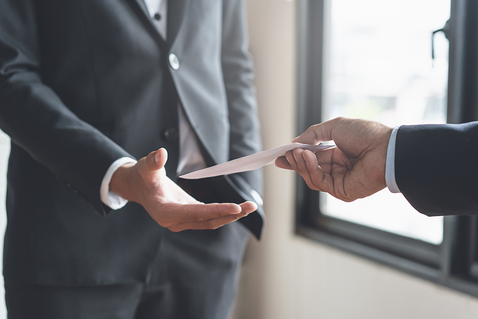 man in suit being handed a folded check