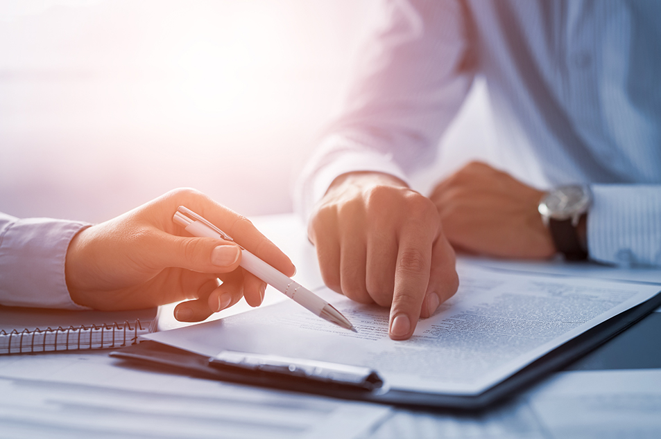 man and woman's hands pointing to and reviewing a contract