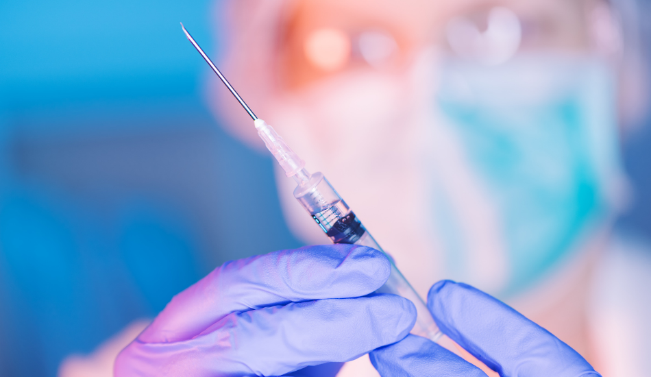 medical professional holding a syringe with a vaccine in it