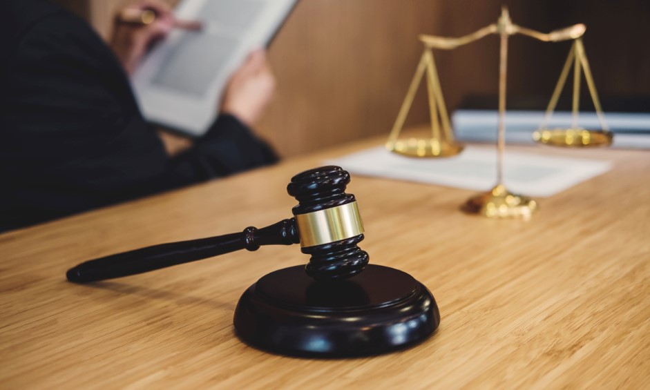 judge's gavel sitting on desk next to scale