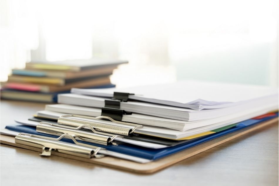 stack of papers bound with clips on a desk